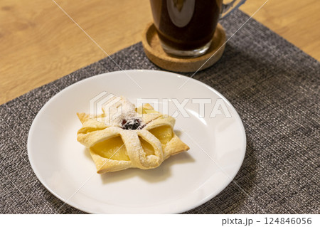 Freshly baked fruit puff pastry on the ceramic plate next to hot cup of coffee Freshly baked fruit puff pastry on the ceramic plate next to hot cup of coffee 124846056