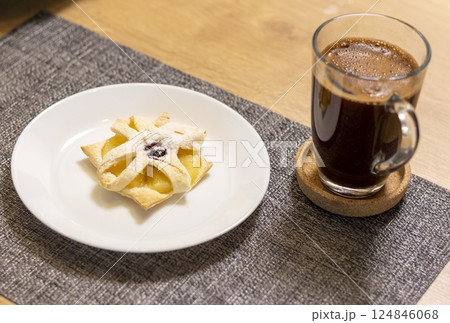 Freshly baked fruit puff pastry on the ceramic plate next to hot cup of coffee 124846068