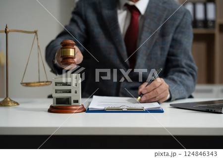 Justice and law concept. Real Estate Law in a courtroom the gavel, working with digital tablet computer on wood table in sun light. 124846343