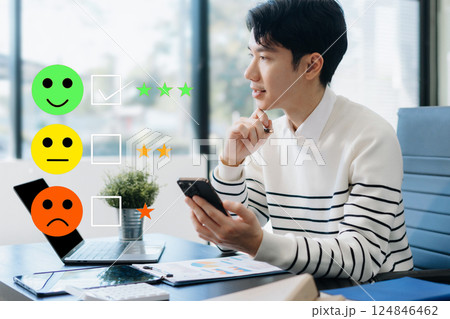 Male businessman holding a digital smartphone with checkboxes rating smiley faces excellent for Satisfaction Survey, Happy Client Customer Experience concept. Male businessman holding a digital smartphone with checkboxes rating smiley faces excellent for Satisfaction Survey, Happy Client Customer Experience concept. 124846462