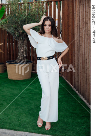 Beautiful slender fashion woman in white suit posing Beautiful slender fashion woman in white suit posing 124849564