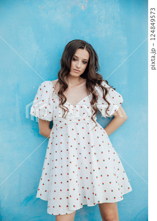 slim fashion brunette woman in summer white dress on blue background 124849573