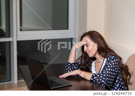 Woman working on laptop at desk 124849719