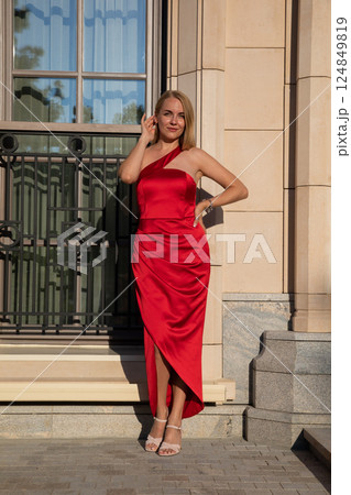 Beautiful woman in a red dress standing at the door Beautiful woman in a red dress standing at the door 124849819