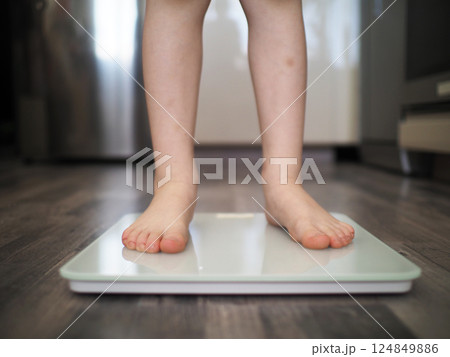 Child feet stepping on weight scale Child feet stepping on weight scale 124849886
