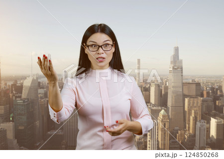 Portrait of asian female boss is scolding you for something outdoors. Urban cityscape background. 124850268