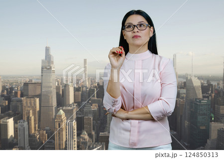 Young asian woman standing outdoors and thinking. Urban city scape background. Young asian woman standing outdoors and thinking. Urban city scape background. 124850313