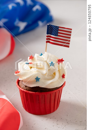 Traditional American sweet cupcake with sugar sprinkles in color USA flag on white background. Vertical format. Dessert for Patriotic Independence Day. 124850795
