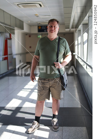 An Adult Man in a Green T-Shirt and Shorts Stands Confidently in a Subway Passage, Capturing the Everyday Life and Unique Style of Urban Commuters in a Bustling Metro Environment An Adult Man in a Green T-Shirt and Shorts Stands Confidently in a Subway Passage, Capturing the Everyday Life and Unique Style of Urban Commuters in a Bustling Metro Environment 124850942