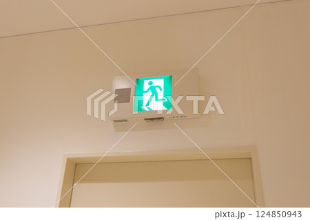 施設内の非常口誘導灯　緑色の人物が走っているサインのピクトグラム 124850943