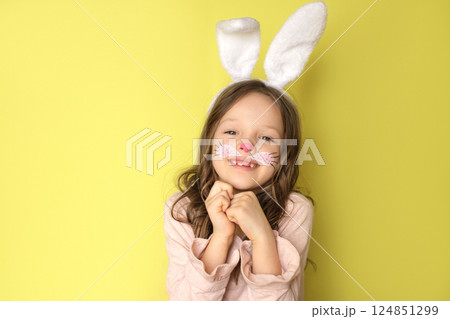 Happy bunny girl with a painted face. Celebration of the feast of Holy Easter Happy bunny girl with a painted face. Celebration of the feast of Holy Easter 124851299