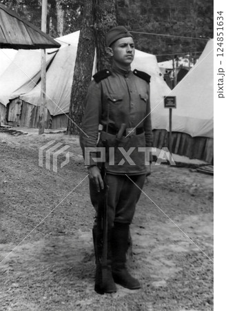 Vintage portrait of a Soviet soldier during training. Tents in the background. Retro photo from 1952. Vintage portrait of a Soviet soldier during training. Tents in the background. Retro photo from 1952. 124851634