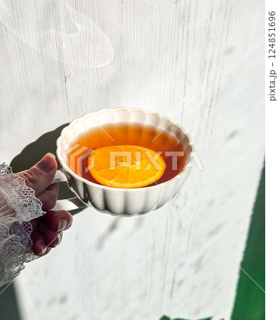 Sunlit Serenity: A Hand Holding a Warm Mug of Tea 124851696