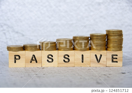 Passive text on wooden cubes with stacking golden coins.Passive text on wooden cubes with stacking golden coins. Passive Income concept Passive text on wooden cubes with stacking golden coins.Passive text on wooden cubes with stacking golden coins. Passive Income concept 124851712