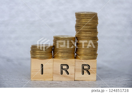 Internal rates of return text on wooden cubes with stacking golden coins. IRR and investment concept 124851728