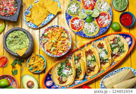 Festive spread of traditional Mexican dishes featuring taco varieties, chalupas, and vibrant sides perfect for celebration days 124852054