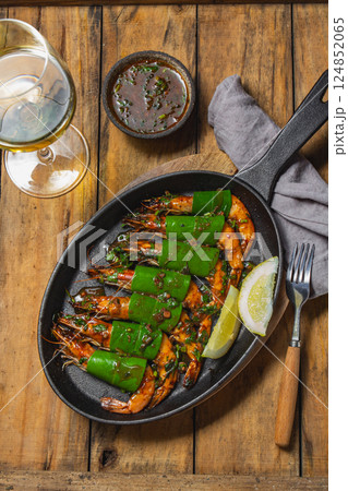 Delicious shrimp with a glass of white wine at a rustic dining table 124852065