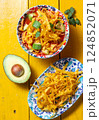 Crispy tortilla topping enhances traditional Aztec soup with vibrant vegetables and fresh avocado on a bright wooden table 124852071