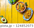 Delicious tortilla fried Aztec soup served with fresh avocado and lime on a vibrant yellow table 124852073