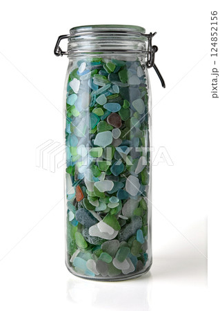 tall glass jar with colorful glass shards from the sea isolated on white background tall glass jar with colorful glass shards from the sea isolated on white background 124852156