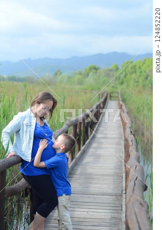 Mother and Son Bonding on a Rustic Wooden Bridge 124852220