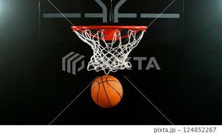 Detail of basketball ball hitting the hoop, top view. Isolated on black background. 124852267