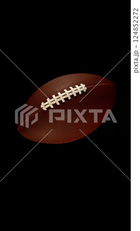 Detail of american football ball isolated on black background. 124852272