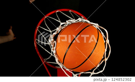 Detail of basketball ball hitting the basket, top view. Isolated on black background. Detail of basketball ball hitting the basket, top view. Isolated on black background. 124852302