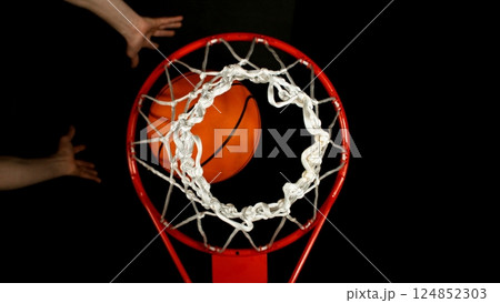 Detail of basketball ball hitting the basket, top view. Isolated on black background. 124852303