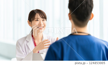 打ち合わせをする男女2人の医療スタッフ 打ち合わせをする男女2人の医療スタッフ 124853005
