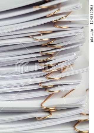 joined white sheets of cellulose paper for records, stapled together white paper for documentation, side view 124853568