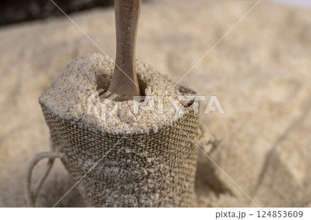 fresh wheat flour close-up, flour for making bread with bran, flour with a wooden spoon, side view 124853609