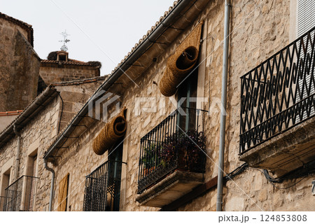 Stone buildings with rolled-up window blinds and balconies in historic Trujillo, Spain. Stone buildings with rolled-up window blinds and balconies in historic Trujillo, Spain. 124853808