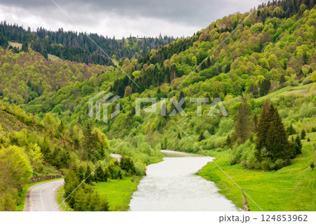 mountain landscape with road along river. nature background for travel. vacation season. green outdoor with forest on the hill. natural environment for adventure in countryside valley mountain landscape with road along river. nature background for travel. vacation season. green outdoor with forest on the hill. natural environment for adventure in countryside valley 124853962