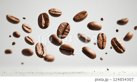 Roasted coffee beans are levitating and falling on a white background, creating a dynamic and aromatic scene, perfect for coffee related projects 124854307