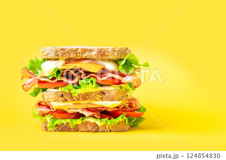 Double bacon, lettuce, tomato sandwich with cheese on yellow 124854830