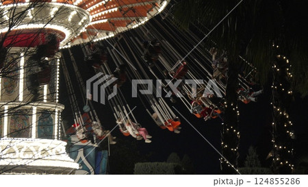Carousel Night Ride Passengers Amusement Park: Illuminated carousel ride at night, showing passengers enjoying the thrill of the spinning attraction. 124855286