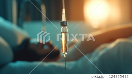 Close up of iv drip with yellow medicine dripping into a blurred patient lying in a hospital bed, highlighting medical treatment and healthcare 124855455