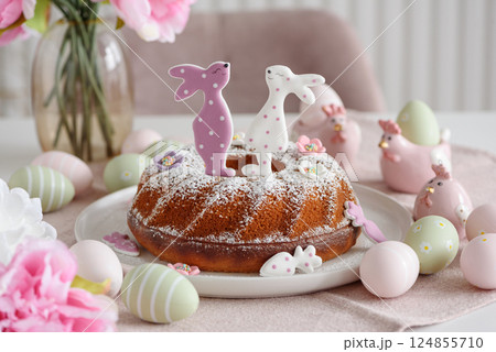 Traditional easter cakes with icing decorated with gingerbread cookies in shape of rabbits on white wooden table 124855710