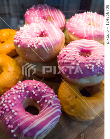 Colorful donuts display on a wooden platter at a festive gathering 124856708