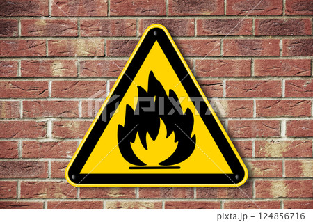 Fire hazard warning sign on a brick wall background Fire hazard warning sign on a brick wall background 124856716