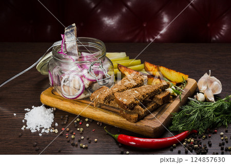 Herring with onions in a glass jar with potatoes 124857630