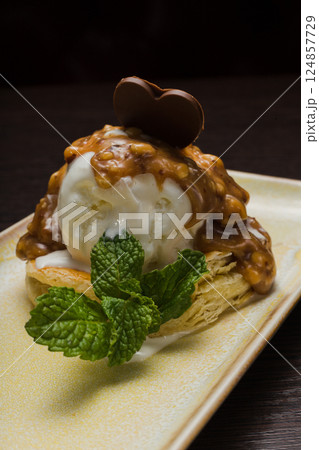 Dessert with puff pastry and ice cream drizzled 124857729
