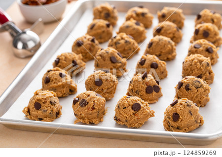 Chocolate chip cookies with pecan nuts, cookie dough ready on a baking sheet Chocolate chip cookies with pecan nuts, cookie dough ready on a baking sheet 124859269