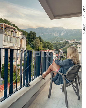 Middle-aged woman relaxing in a chair on a balcony 124859546