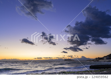 稲村ヶ崎の海岸から静かに沈む夕日を眺める旅情あふれるワンシーン 124859562