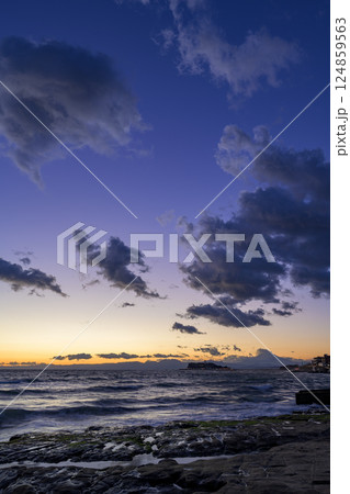 湘南の名所・稲村ヶ崎から見た、波間に輝く夕日と幻想的な空の色彩 124859563
