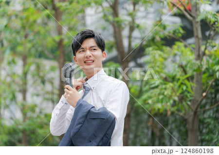 ハンディファンを持つ夏のビジネスマン 124860198