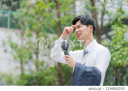 ハンディファンを持つ夏のビジネスマン ハンディファンを持つ夏のビジネスマン 124860203