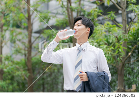 公園で水を飲むサラリーマン 124860302